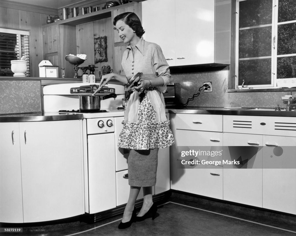 Woman stirring pot at stove