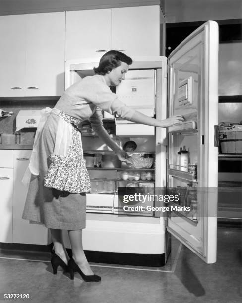 housewife at refrigerator - 1950s housewife stockfoto's en -beelden