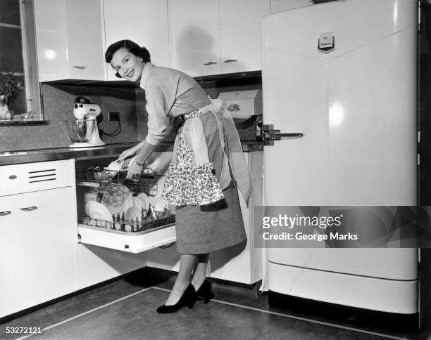 apron housewife at kitchen dish washer - retro wife stock pictures, royalty-free photos & images