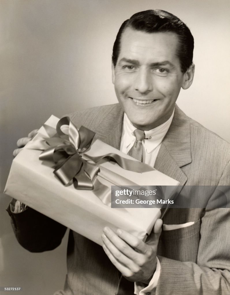 Man presenting gift wrapped with ribbon