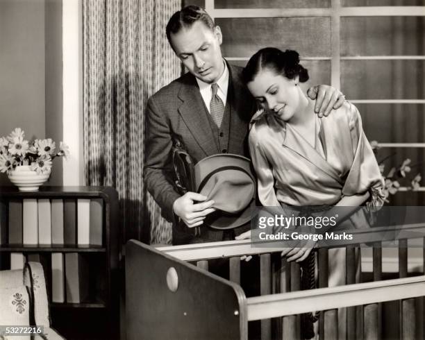 mother and father looking at baby - 1950s couple stock pictures, royalty-free photos & images