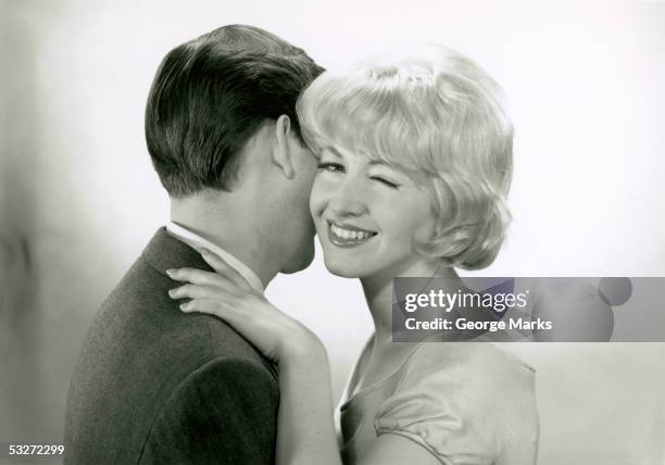 man embracing winking woman - retro couple stock pictures, royalty-free photos & images