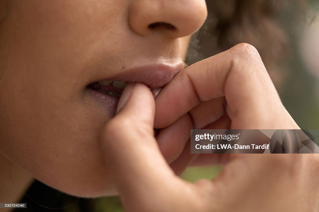 Young Woman Biting Fingernails