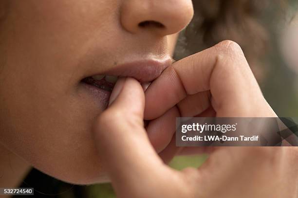 young woman biting fingernails - woman mouth stock pictures, royalty-free photos & images