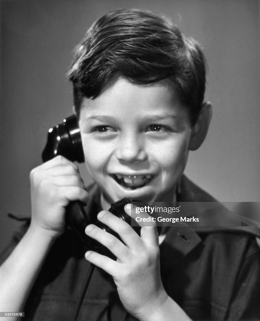 Young boy talking on telephone