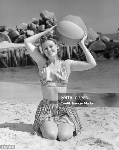 woman on beach holding beach ball - 1950s beach ball stock pictures, royalty-free photos & images