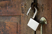 unlocking padlock  on a wooden door