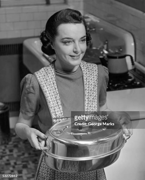 housewife hoding roasting pan - 1950 females only housewife stockfoto's en -beelden
