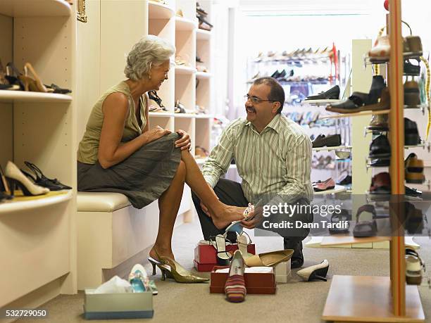 shoe store employee helping customer - shoe shopping stock pictures, royalty-free photos & images