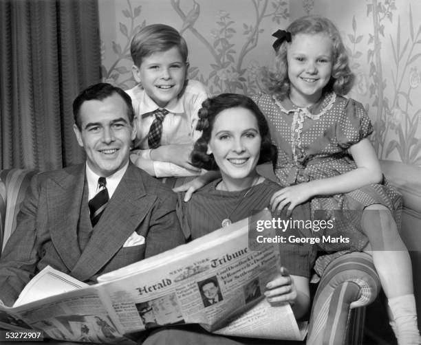 family on couch w newspaper - 1950s father stock pictures, royalty-free photos & images