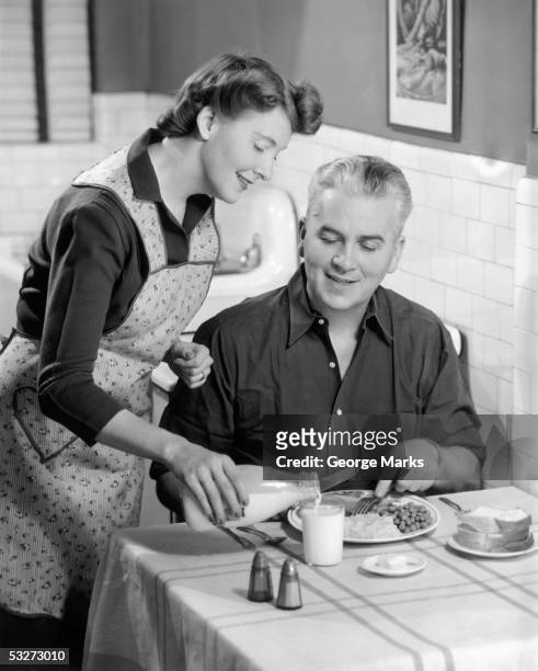 housewife serving dinner to husband - 1950s housewife stock-fotos und bilder