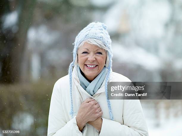 woman in snowfall - mature woman winter stock pictures, royalty-free photos & images