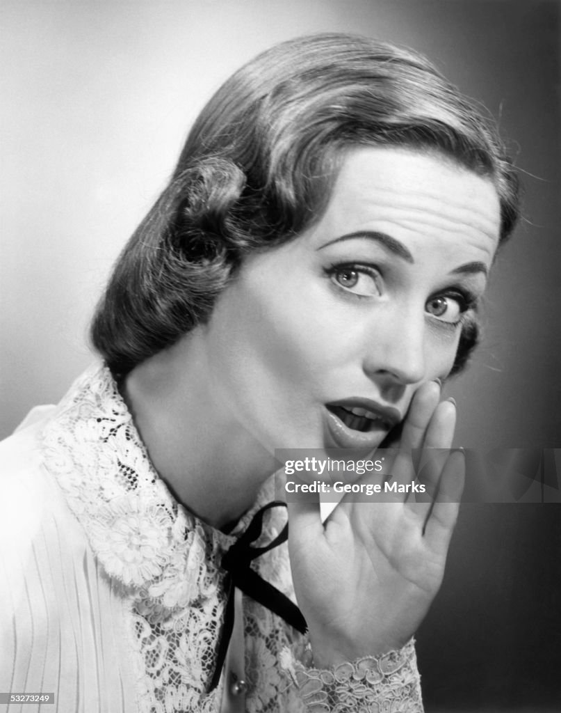 Woman speaking with hand cupped around mouth