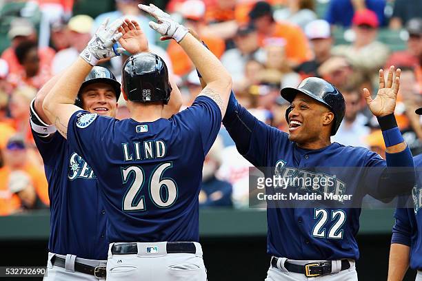 Robinson Cano of the Seattle Mariners and Kyle Seager congratulate Adam Lind at home plate after he hit a three runhomer during the sixth inning...