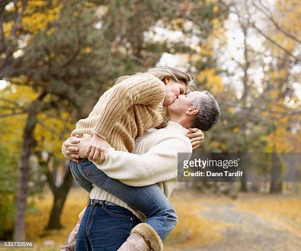 couple kissing in park - 55 59 anni foto e immagini stock