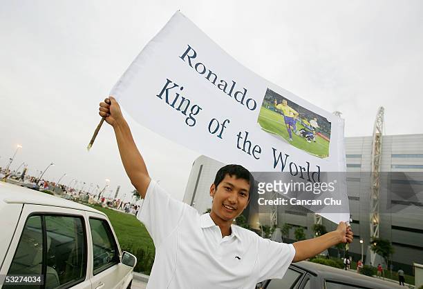 Chinese fan lifts a banner as he waits to see the Real Madrid team before they arrive the Teda Stadium for a training session on July 22, 2005 in...