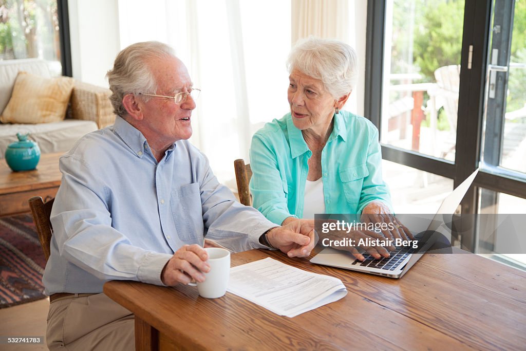 Senior couple using computer together at home