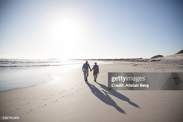 senior couple together at beach - beach footprints stock pictures, royalty-free photos & images