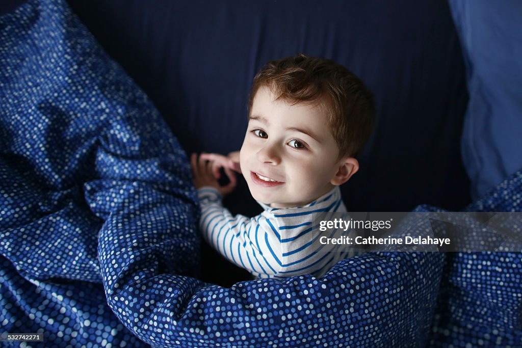 A 3 years old boy in his bed