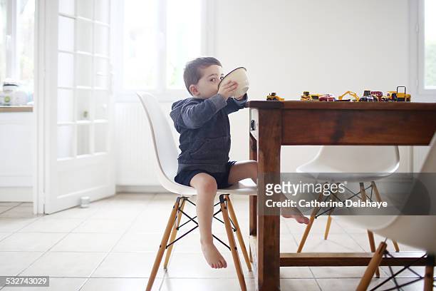 a 3 years old boy taking his breakfast - barefoot boy fotografías e imágenes de stock