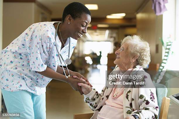 nurse greeting elderly woman - kindness stock pictures, royalty-free photos & images