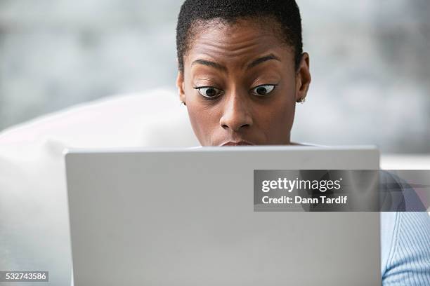 shocked woman using a laptop - mistake stockfoto's en -beelden