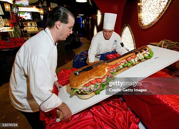 Harrah's Las Vegas director of culinary operations Tim Bowen and assistant executive chef John Maltby move a 90-pound hamburger during the grand...