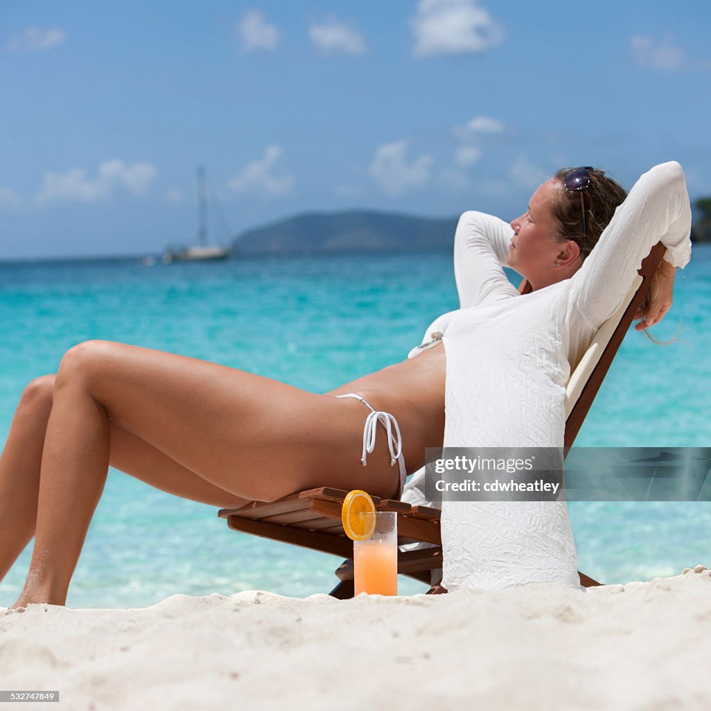Woman enjoying a tropical cocktail at the Caribbean beach