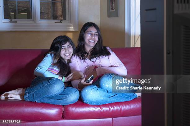 sisters watching television - arab watching tv stock-fotos und bilder
