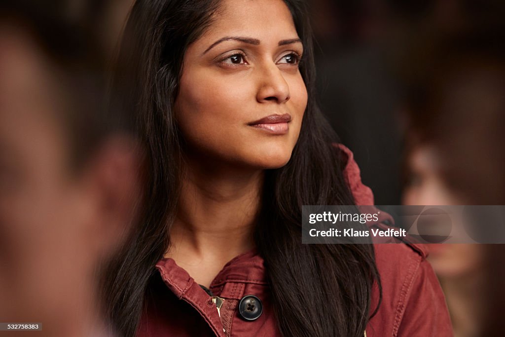 Portrait of beautiful woman in crowd, looking out