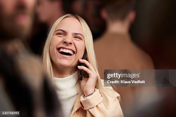 woman on the phone laughing, among crowd - one kid one world a night of 18 laughs stockfoto's en -beelden