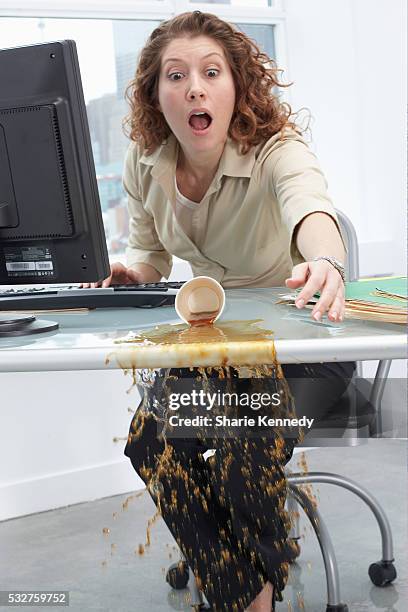 businesswoman spilling coffee on desk - coffee spill stock pictures, royalty-free photos & images