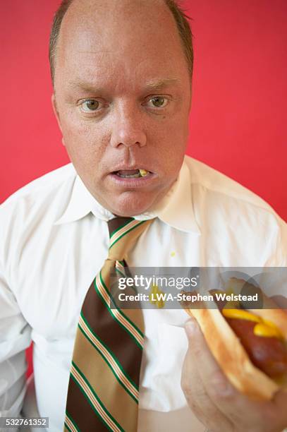 businessman eating hot dog - white shirt stain stock pictures, royalty-free photos & images