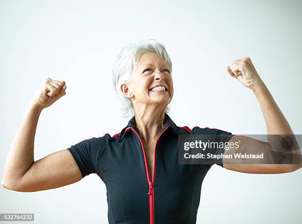 smiling woman flexing arms - fist raised stock pictures, royalty-free photos & images