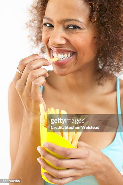 woman eating french fries - french fries white background stock-fotos und bilder