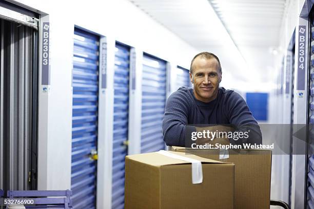 man with boxes in a storage facility - self storage stock pictures, royalty-free photos & images