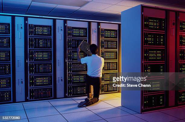 man inspecting mainframe computer - mainframe stock-fotos und bilder