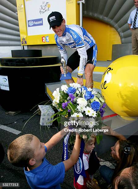 Lance Armstrong of the USA riding for the Discovery Channel cycling team gives flowers to his children Luke, Grace and Isabella as girlfriend Sheryl...