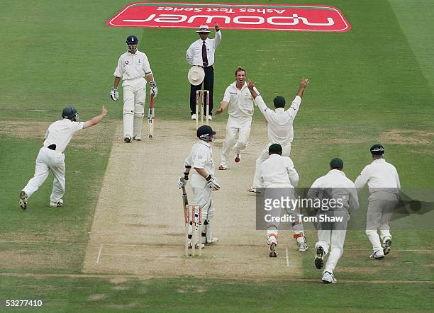 Shane Warne of Australia celebrates the wicket of Ian Bell of England with team mates during day three of the first npower Ashes Test match between...