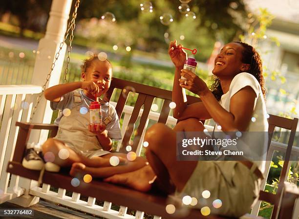 mother and daughter blowing bubbles - swing chair stock pictures, royalty-free photos & images