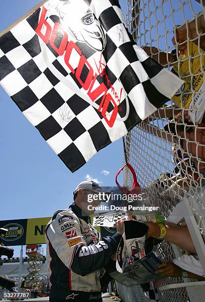 Jimmie Johnson, driver of the Lowe's Chevrolet, signs autographs during qualifying for the NASCAR Nextel Cup Pennsylvania 500 on July 23, 2005 at the...