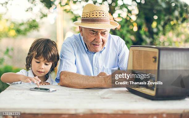 portrait of a small boy with his grandfather - radio photos et images de collection