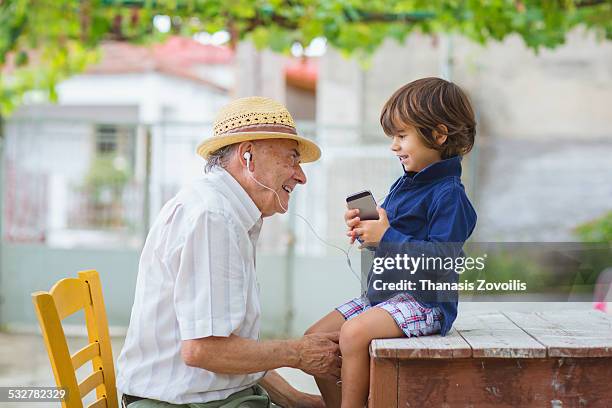 small boy with his grandfather - sharing headphones stock pictures, royalty-free photos & images