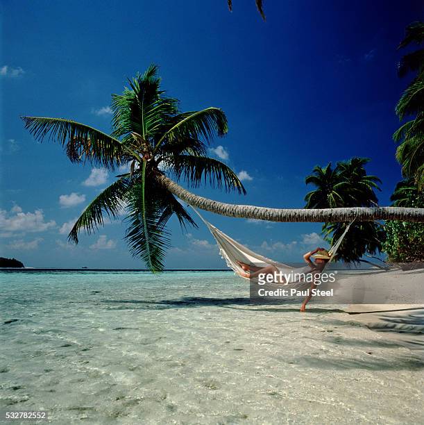 relaxing on tropical beach - woman hammock photos et images de collection