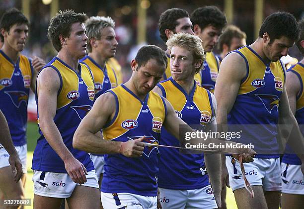 Eagles players leave the field dejected after being defeated by the Swans in the round seventeen AFL match between the Sydney Swans and the West...