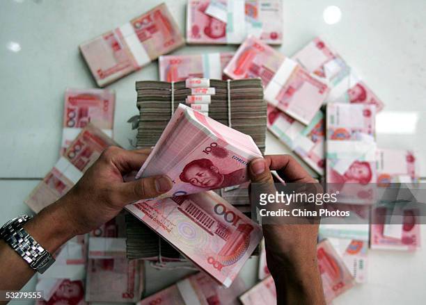 Clerk counts stacks of Chinese yuan at a bank on July 22, 2005 in Beijing, China. The People's Bank of China, the central bank, announced on July 21...