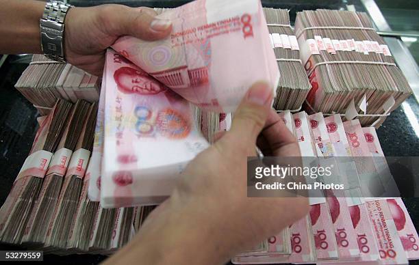 Clerk counts stacks of Chinese yuan at a bank on July 22, 2005 in Beijing, China. The People's Bank of China, the central bank, announced on July 21...