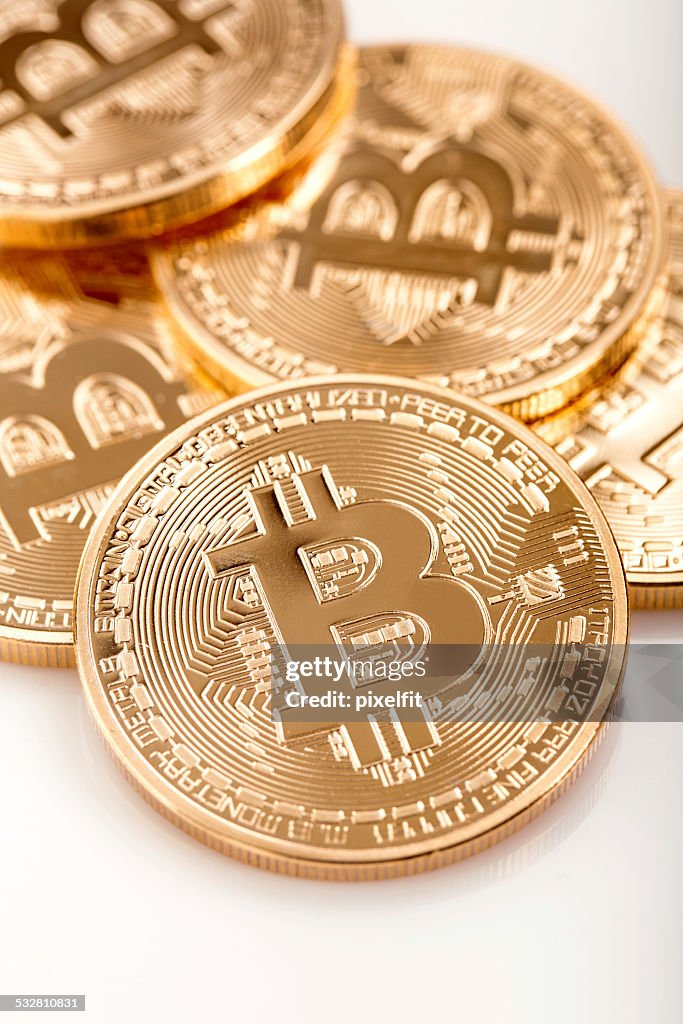 Few golden bitcoins on white background.