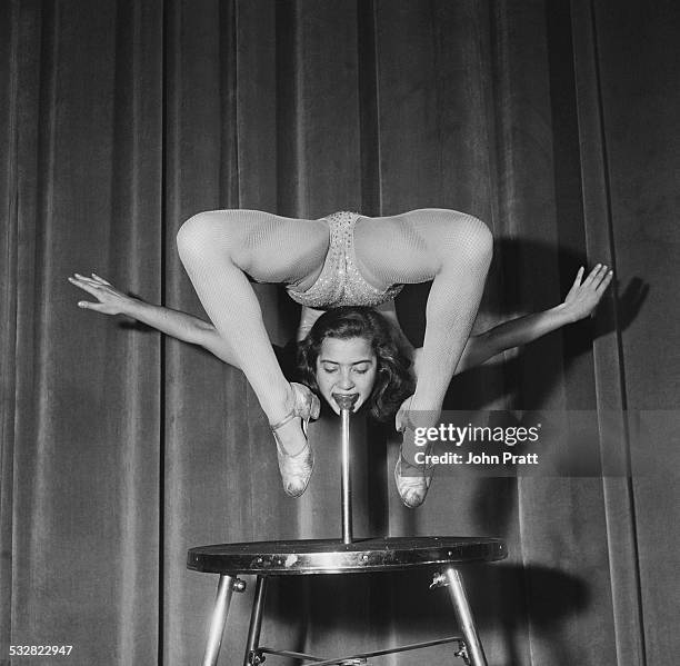 Eighteen year-old Austrian acrobat Eleonore Gunter, bending over double as she supports her weight from her mouth by biting on a specially-designed...