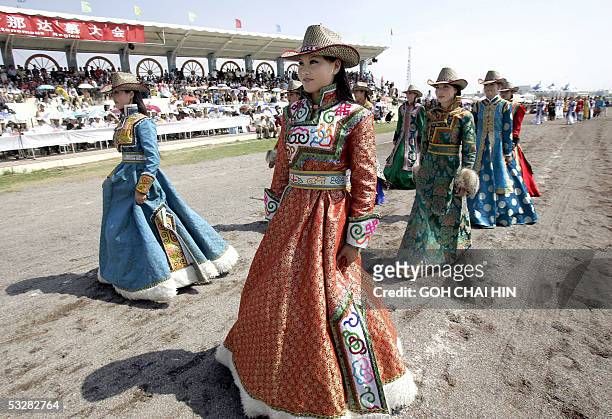Chinese Mongolian models show off the various traditional outfits during a parade to mark the start of the Naadam festival on the grassland of...